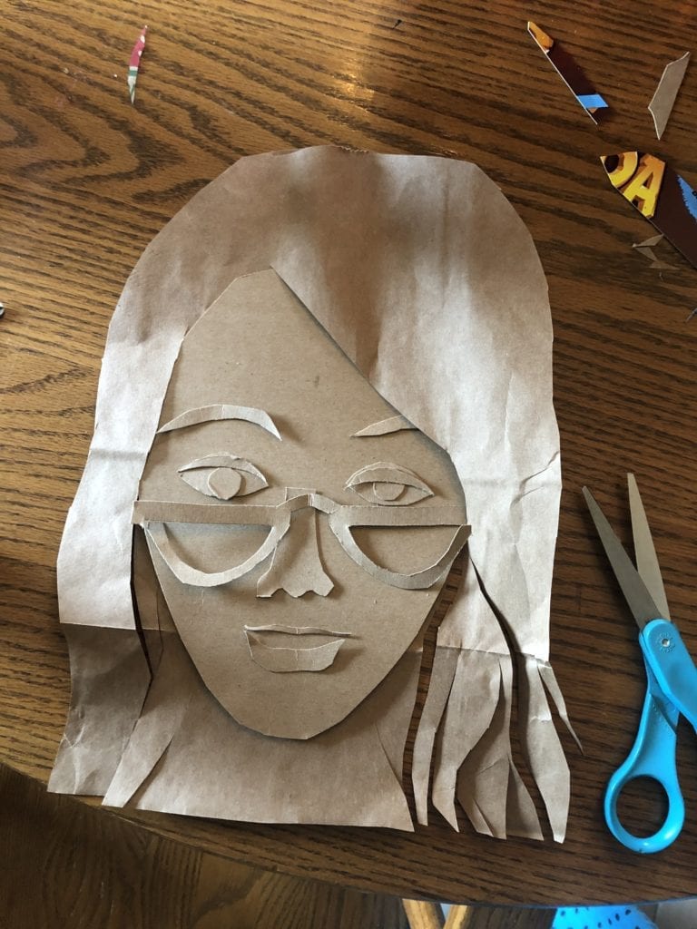 portrait that has hair, glasses, and a face made from light brown cardboard