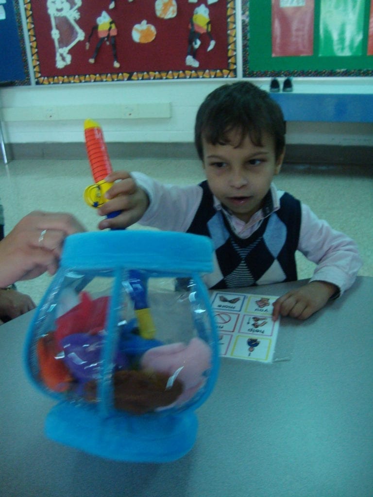 student playing with fish bowl toy with colored fish