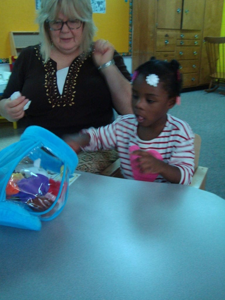 student playing with fish bowl toy with colored fish