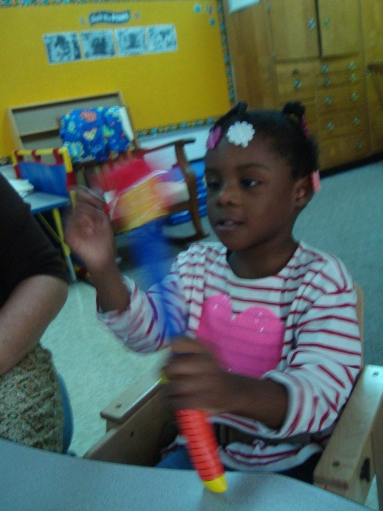 student playing with fish bowl toy with colored fish