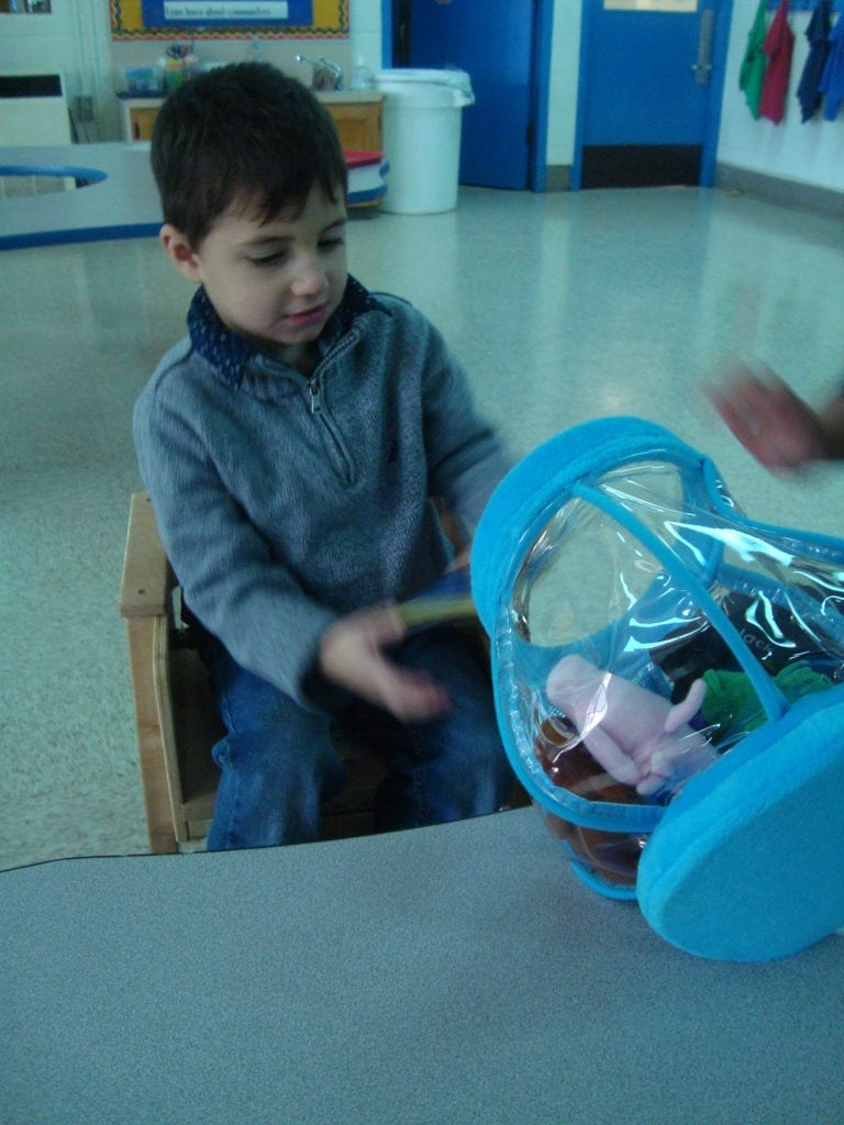 student playing with fish bowl toy with colored fish