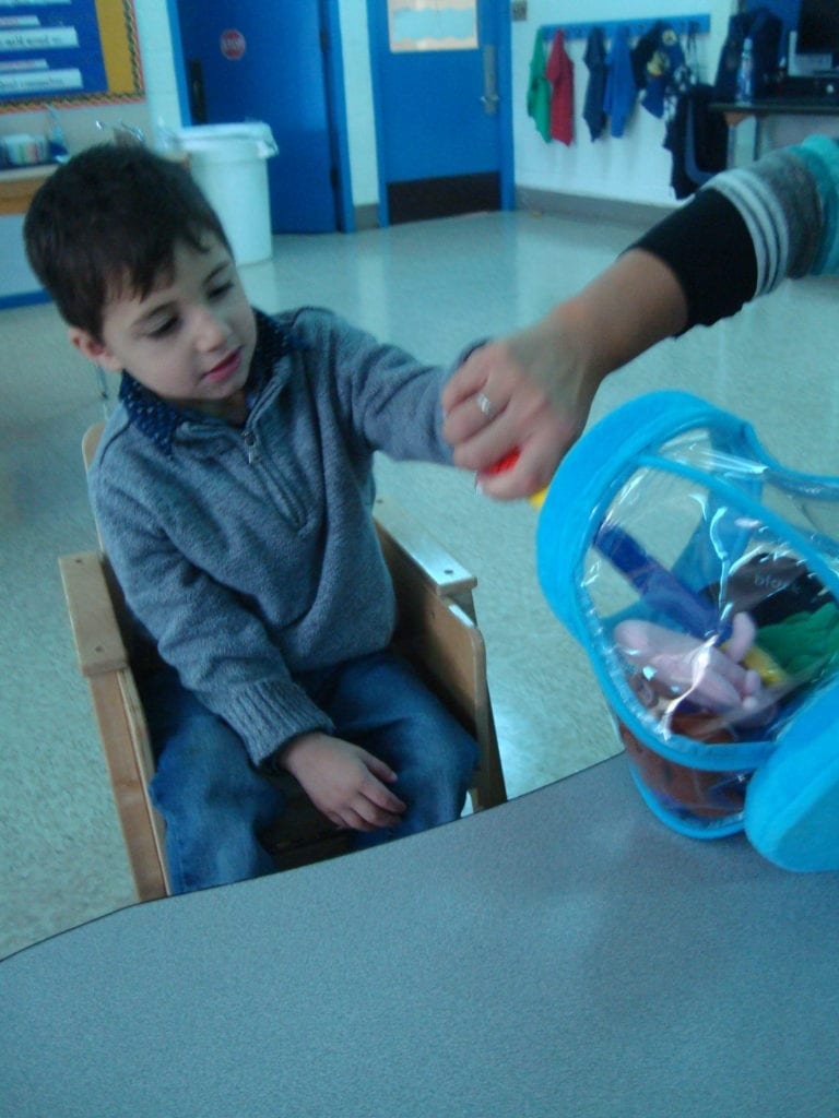 student playing with fish bowl toy with colored fish