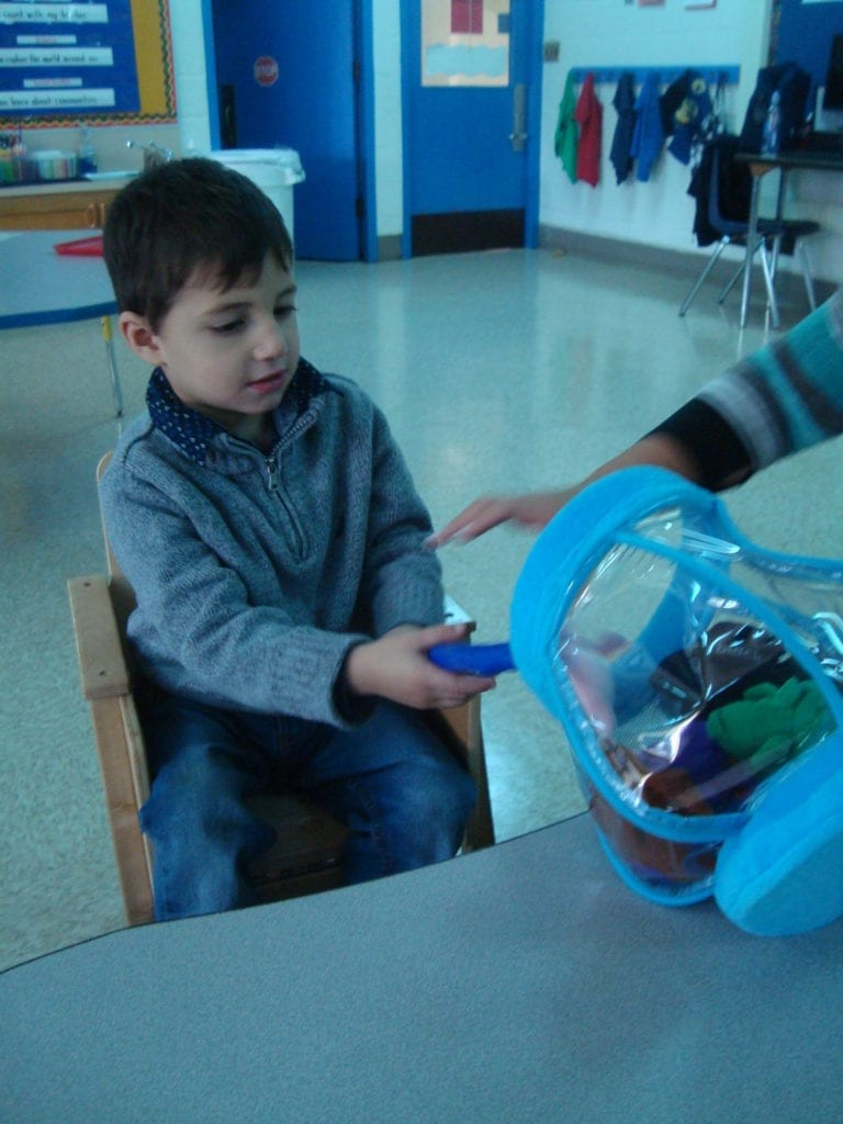student playing with fish bowl toy with colored fish