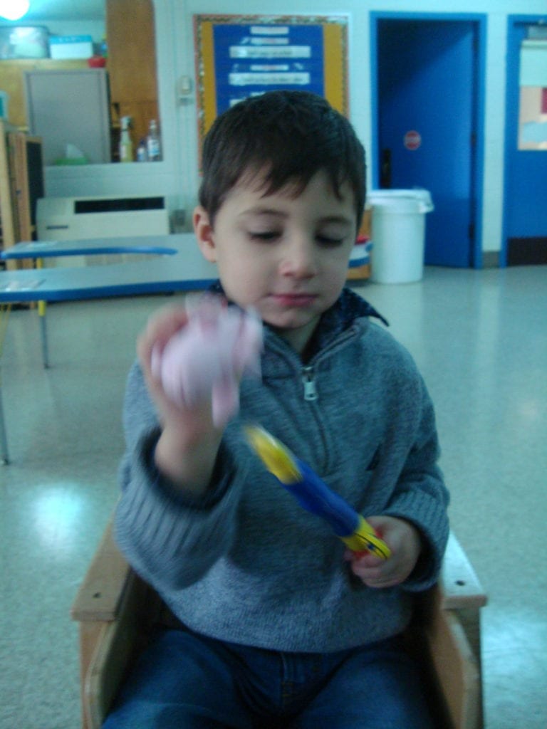 student playing with fish bowl toy with colored fish