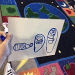 Studetns drawing on a whiteboard of the butterfly lifecycle.