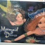 photo of two mermaids swiming under sea