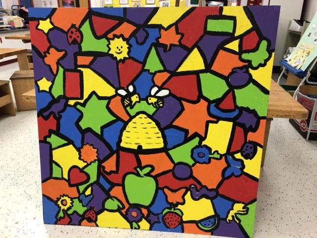 Colorful geometric and organic shapes are included with apple, heart, butterfly, beehive and insect shapes on a large mural