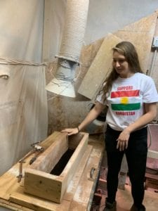 Woman standing next to clay mixer.