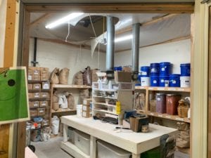 shelves lined with buckets, boxes and bags of materials used to make clay