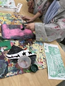 image of a student rolling paint on their printing plate with a brayer