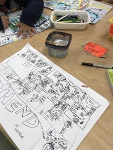 student hands drawing on a white paper
