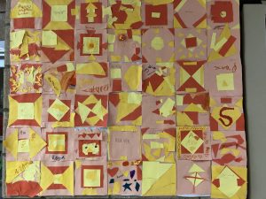 Second grade paper quilt squares using yellow and orange construction paper