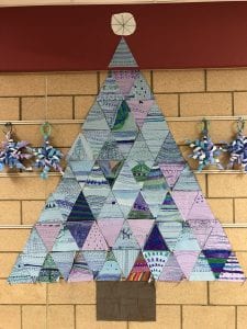 Winter tree made up of triangle paper pieces. Students used mainly purple, green, and blue from the cool color family.