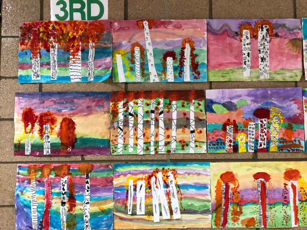 landscape showing birch trees with painted leaves of red, yellow, and orange colors. Landscape background is done with watercolor paints.