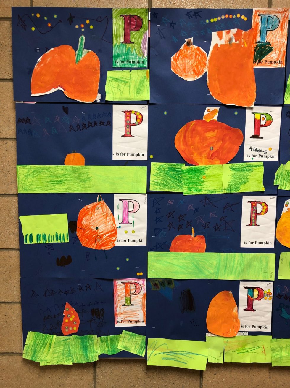 P is for Pumpkin artwork by kindergarten. Painting of a pumpkin glued to a dark blue background with stars and construction paper grass