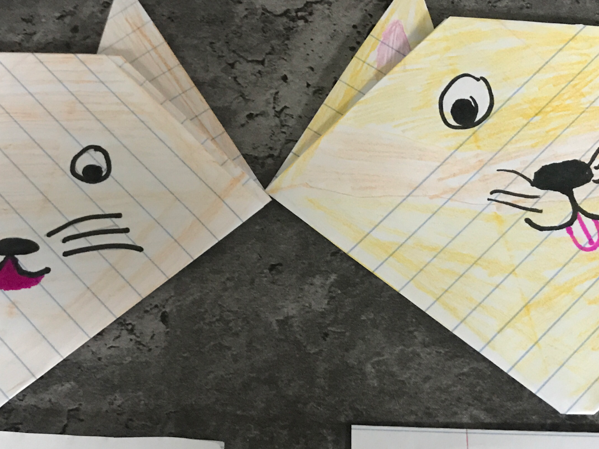 origami cat heads made by folding paper with drawn faces