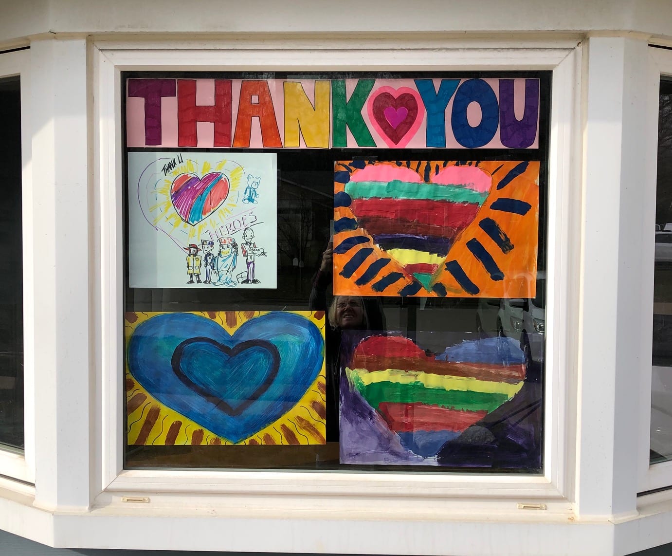 heart paintings displayed in window with thank you message