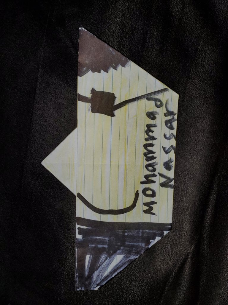 folded paper to make a crescent moon shape with drawn sunglasses