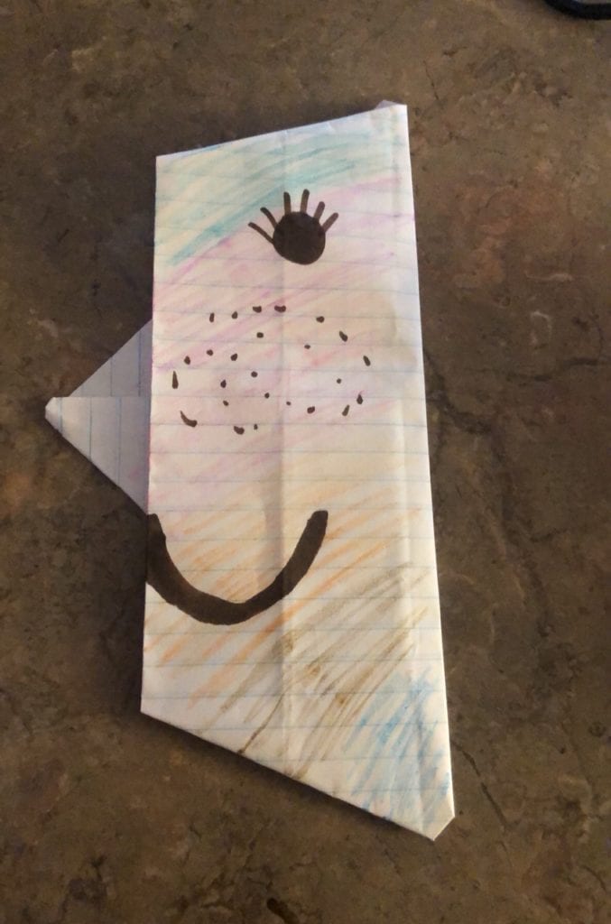 folded paper to make a crescent moon shape with a face