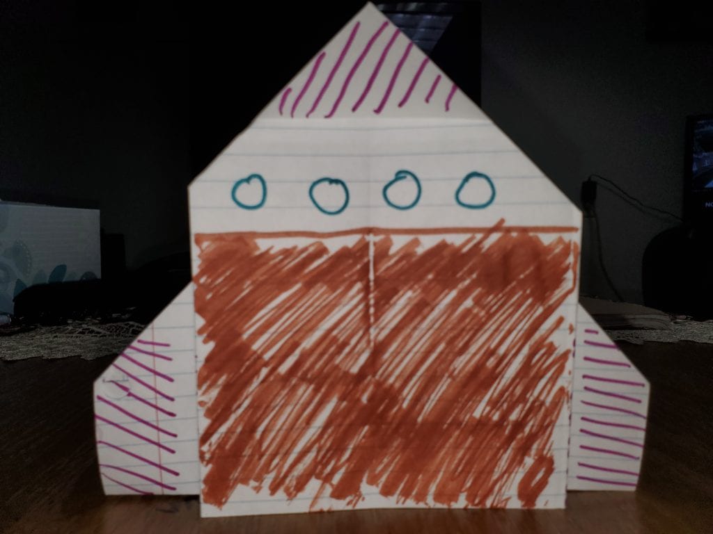 folded paper to make a rocket shape and colored with markers