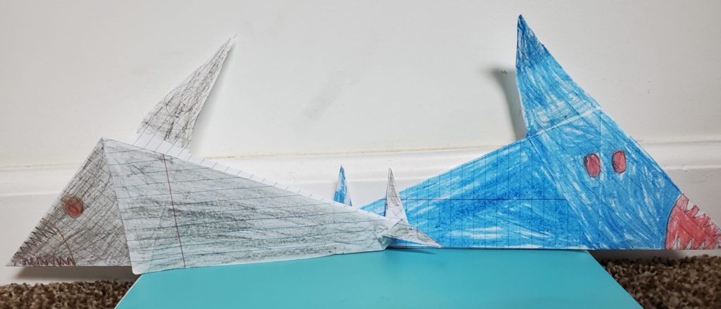 origami sharks folded from notebook paper and colored with crayons