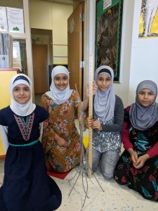 Girls using pipe cleaners to create a tower.