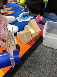 First graders building a house out of blocks.