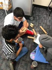 3 students use cardboard to create projects