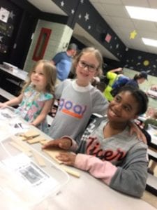 three students showing science project