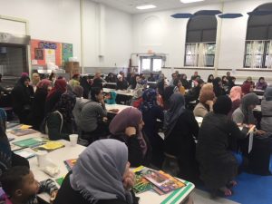 Women sitting at tables listening to speaker.