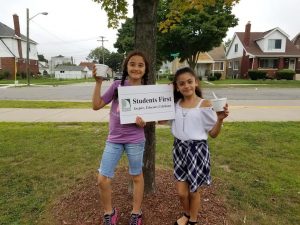 two students holding sign