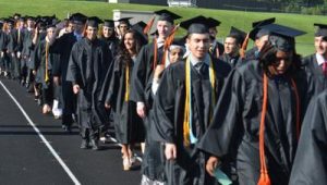 Dearborn High School students walk along the track to the bleachers on the field at the start of the ceremony. (Photo by Joe Slezak)