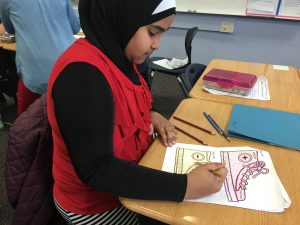 Student coloring and decorating their shoes for project