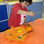Student painting a mini pumpkin