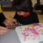 Student putting stickers on a bag
