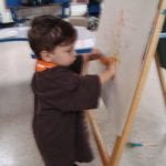 Student painting at easel
