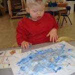 student finger painting