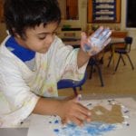 student finger painting
