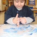 student finger painting