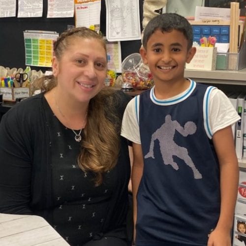student Ebrahim with teacher Ms. Fouani posing in classroom for student of the month photo