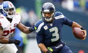 image of Wilson holding a football in uniform with another player coming up behind him. Mandatory Credit: Joe Nicholson-USA TODAY Sports
