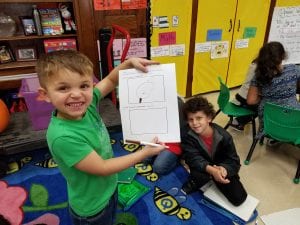 Book buddies working together to record their claim about pumpkins floating!