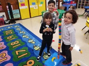 We are building with our friends! We make a tall tower! Look how proud we are!