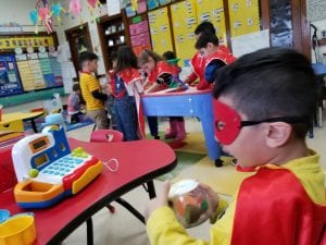Here is another one of our little superheros enjoying using the cash register during recess!