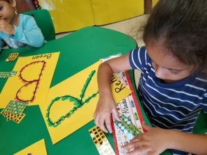 Then....we strengthened our fine motor muscles in our hands by placing small stickers on those letters!