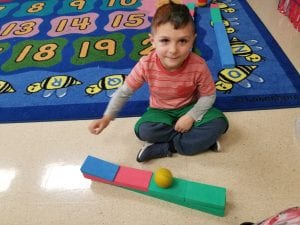 We explored the big blocks with balls! This friend discovered he could make a ramp for his ball to roll down! This is an observation of gravitational force pulling an object.