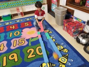 This friend discovered a fun game to play as he used a longer block to push the ball down a path.