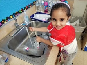 This friend is washing the paint brushes we used as we painted letter Ww with watercolors!