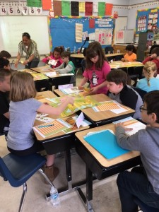 Kids playing a banking game, learning about deposits and withdrawing money. 