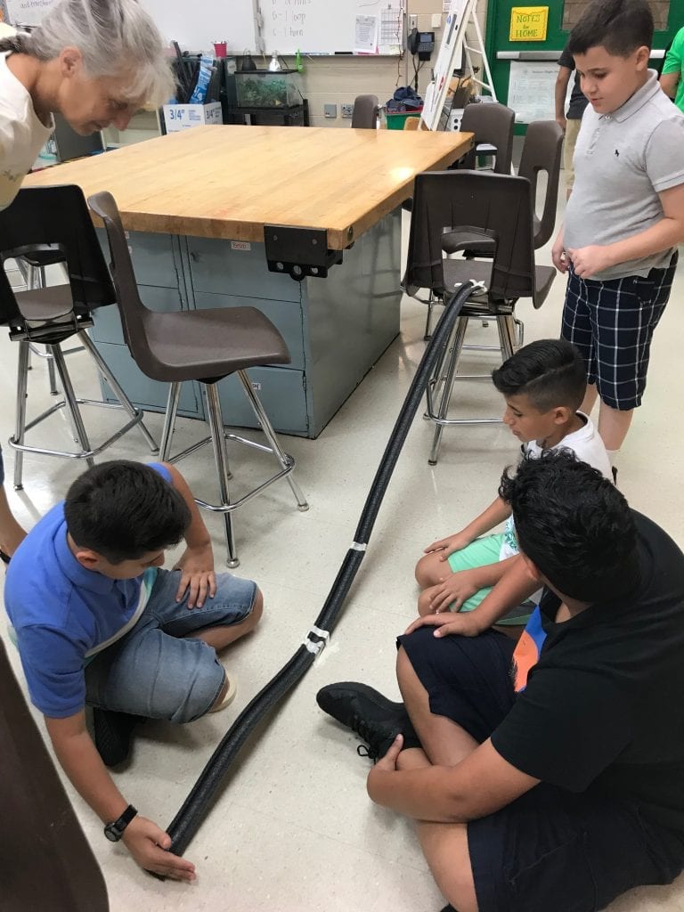 5th Grade students building roller coasters using pipe insulation and tape.